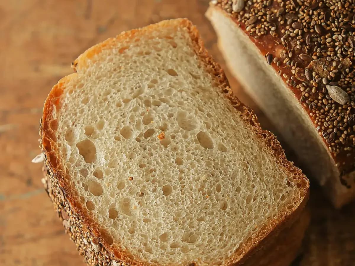 Sliced soft sourdough sandwich bread loaf with a golden crust